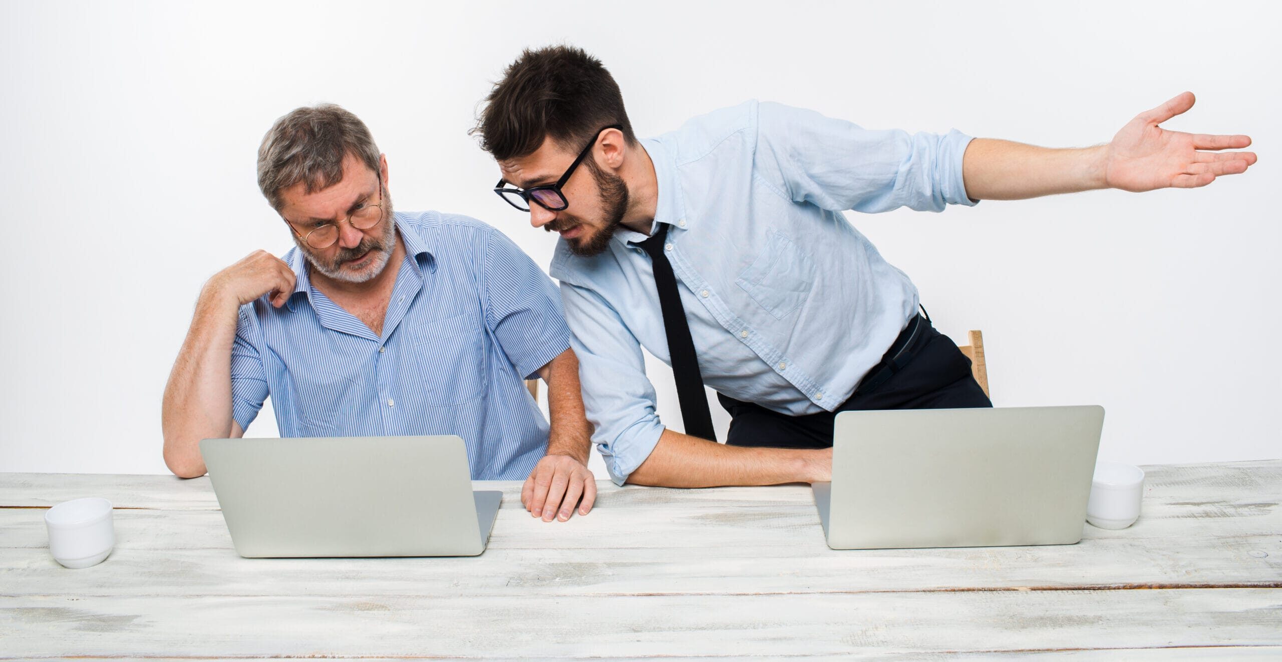 two colleagues working together office white background they discussing something both are looking one computer screen 1 scaled e1736687848684